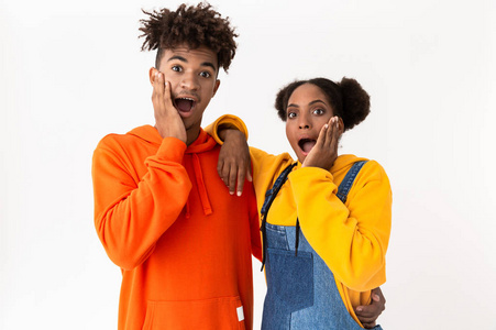 非开放令人惊讶的非裔美国人夫妇穿着五颜六色的衣服,好奇地在白色