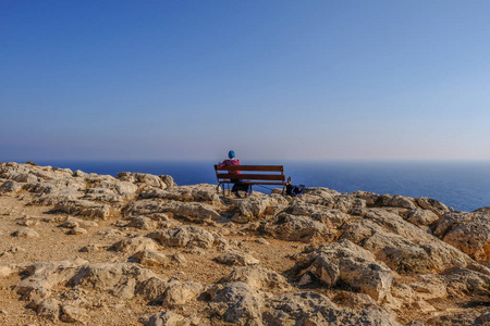 在塞浦路斯的格雷科角,一个年轻的陆地静静地坐在长凳上眺望大海.照片
