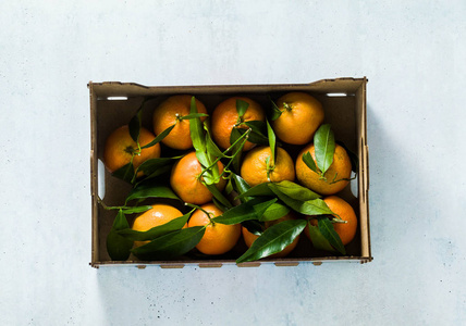 新鲜柑桔水果或橘子，木箱内有叶子，俯视