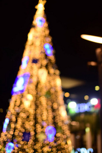 抽象模糊的蓝色和银色闪闪发光的灯泡灯背景模糊的圣诞壁纸装饰概念。圣诞节灯夜抽象圆形的背景。