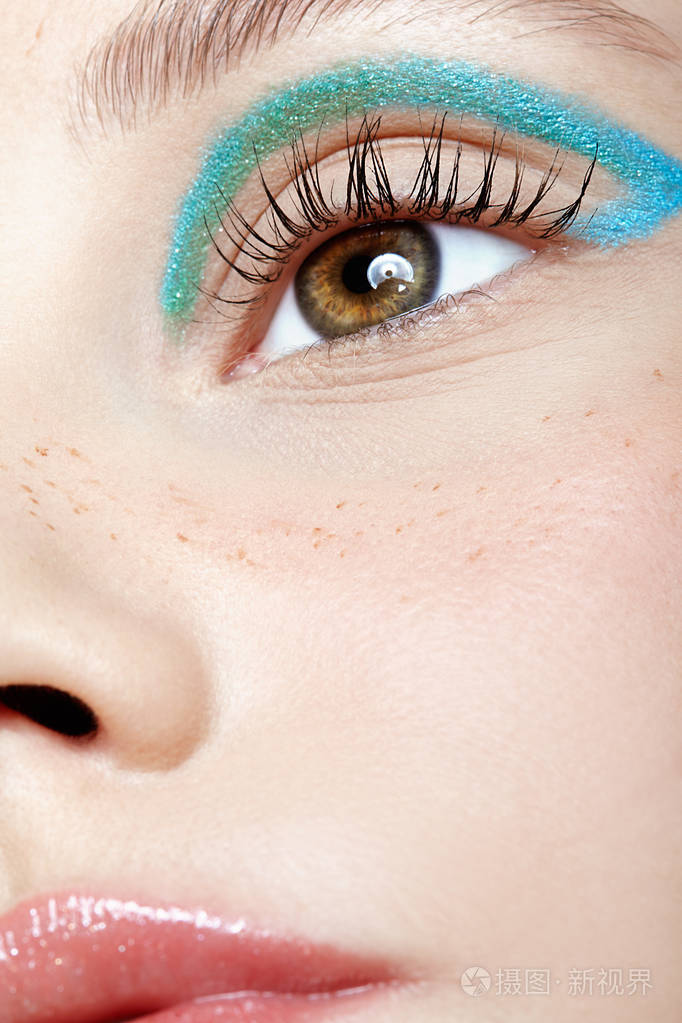 人类女性脸的特写镜头. 有完美皮肤和蓝色烟雾眼睛的女孩眼影.