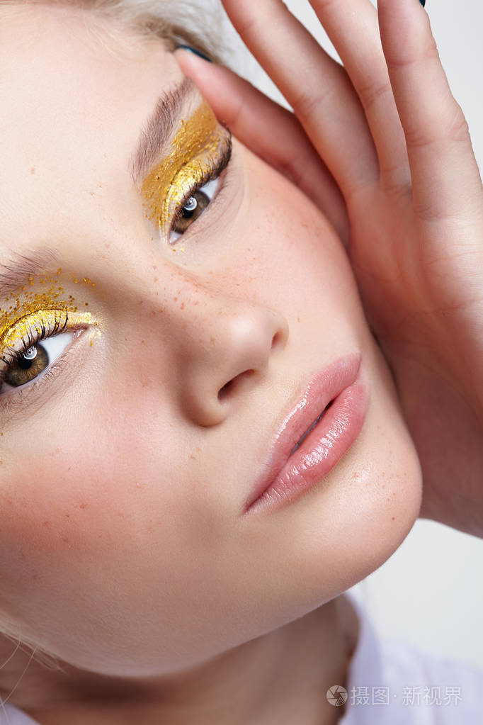 灰色背景下一个年轻金发女人的情感肖像女性挤压面部皮肤