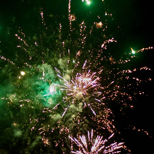 烟花火箭在绿色的夜空中爆炸，烟雾和火花不断