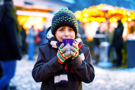 快乐的孩子在传统家庭市场在德国, 笑男孩在五颜六色的冬天衣裳照片