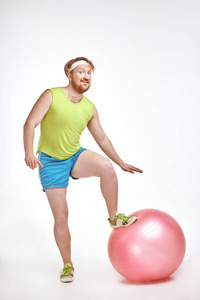红头发, 留胡子, 丰满的人把他的腿一个健身球