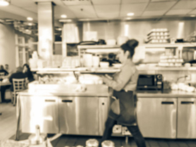 动作模糊的女服务员在美国芝加哥的早餐餐厅厨房端着点的菜