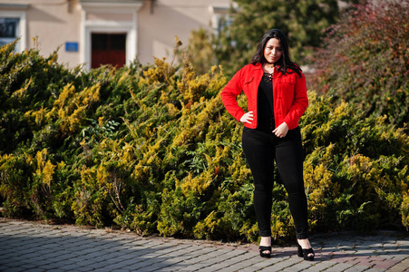 来自厄瓜多尔的漂亮拉丁模特女孩穿着黑色和红色夹克在街上摆姿势。