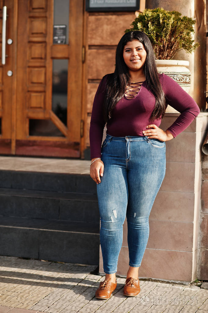 来自厄瓜多尔的漂亮拉丁裔xxl模特女孩穿着紫罗兰色的衬衫在街上摆