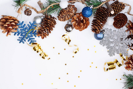 圣诞节和新年作文。 冷杉树枝，圆锥形和圣诞球，银色和蓝色，白色背景。 平躺顶部视图复制空间文本
