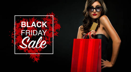 黑色星期五销售理念。购物妇女举行红色袋子孤立在黑暗背景假日