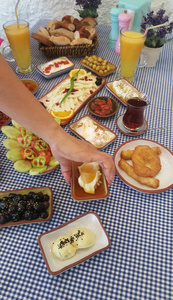 裁剪的妇女提供传统的土耳其早餐桌与各种菜肴。