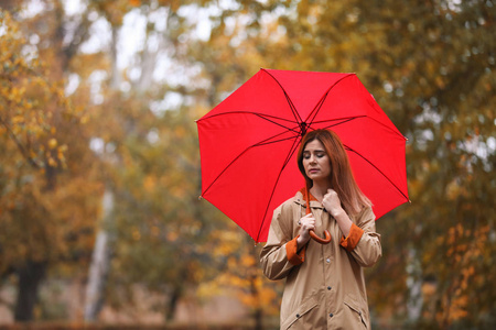 雨天秋天公园有伞的女人