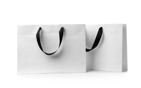 白色背景上带丝带手柄的纸购物袋。 设计模型