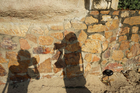 阳光明媚的一天,墙上的男女摄影师的影子照片