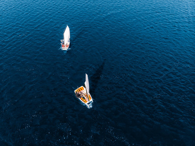 空中无人机比赛在蓝色的海水上运动白色游艇和船只