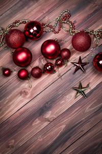 顶部拍摄闪亮的球和星星，红色和金色，木制背景上的装饰品，圣诞节和庆祝的概念