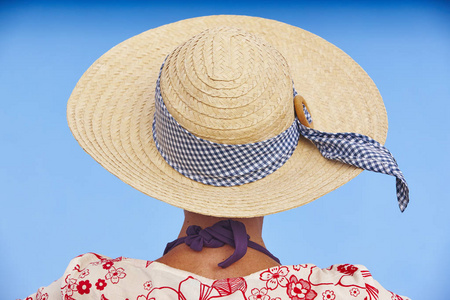 夏日时光。带帽子和蓝色背景的女人。放松时间