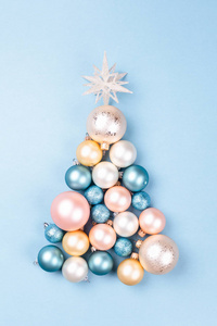 用蓝色背景上的圣诞球制成的圣诞树。 最小的新年概念。