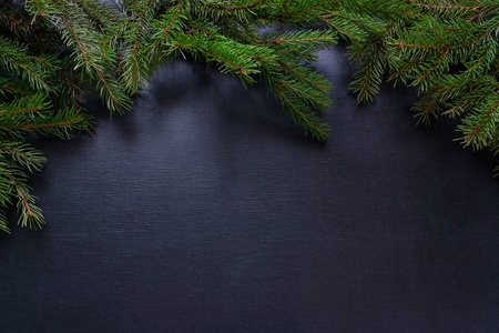 圣诞节和新年快乐假期背景与天然杉木云杉木黑色背景冬季贺卡概念与复制空间的文本。 节日旗帜