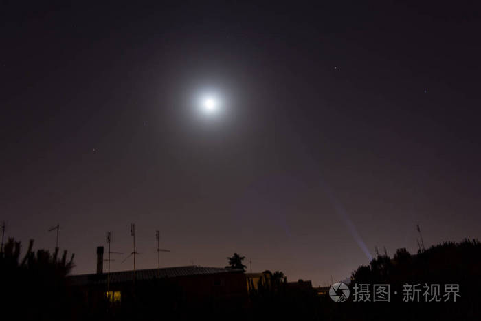 夜晚的月亮和屋顶的房子和建筑物的小镇。