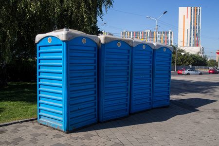 公园里的便携蓝色生物厕所小屋排成一排
