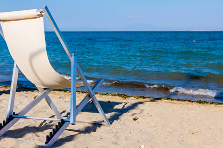 躺椅放在沿着水边的海岸线旁边。