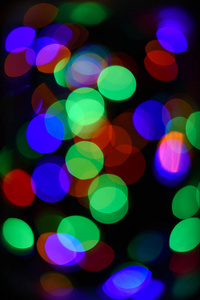 抽象五颜六色的博克背景。节日背景与五颜六色的灯光。即将到来的假期的明亮和节日气氛。圣诞装饰品的概念。五颜六色的花环的失速