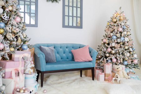 圣诞树下面有礼物在白色客厅里。 带有圣诞节和新年装饰的室内节日房间。