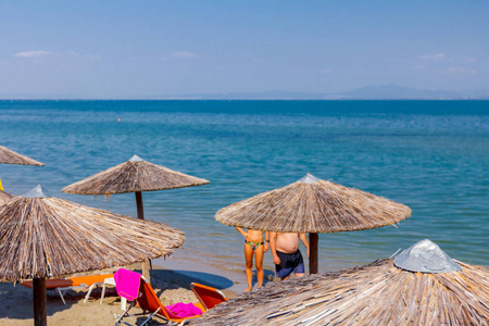 上图是遮阳伞和躺椅上的风景，游客可以在公共海滩度假。