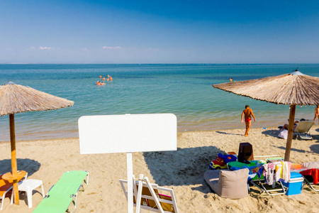 信息横幅彩色木板站在公共海滩前。