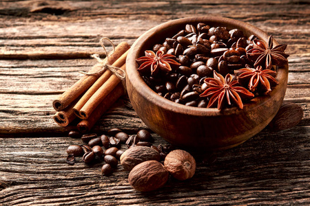 咖啡八角肉桂和肉豆蔻在木碗的木制背景。