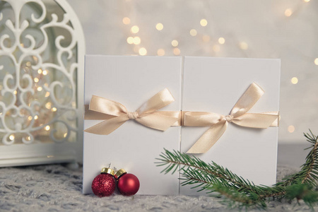 两个圣诞礼物在白色盒子与轻丝带在明亮的背景。新年假期组成横幅。为您的文本复制空间