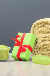 水疗组合物与软特里毛巾礼品盒碗与海盐和肥皂在灰色背景。