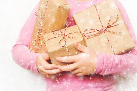 孩子在白色背景上拿着圣诞装饰和礼物。 选择性聚焦。 快乐。