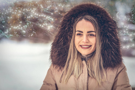 圣诞节在冬天的户外微笑的年轻女人。冬雪夜