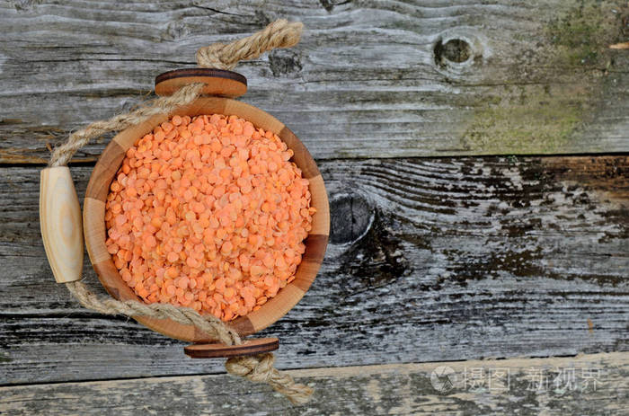 烂木桌上桶里的红色扁豆