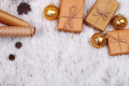 圣诞装饰配件包装纸和包装在工艺纸礼品盒的背景白色毛皮。 乡村圣诞节和新年概念。