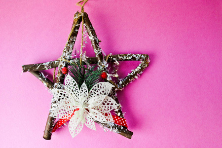大型装饰美丽的木制圣诞明星, 一个自制的风信子树枝和木棍的花环上的节日快乐粉红色紫色快乐的背景。节日装饰品