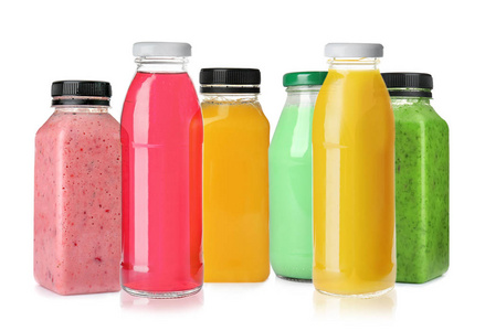 白色背景上装有不同果汁的瓶子照片