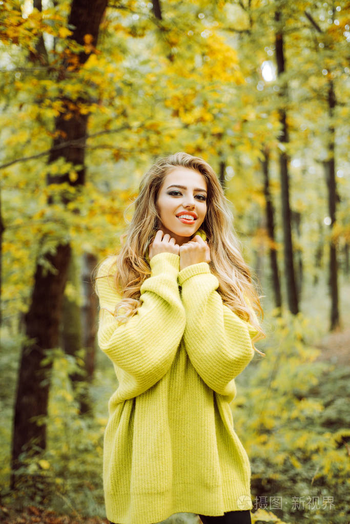 户外时尚照片的年轻美丽的女士包围秋叶.