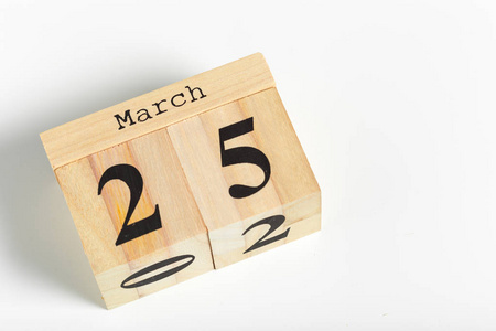 白色背景上有日期的木制立方体。3月25日