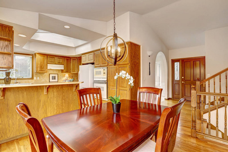 厨房室内部在美国房子与樱桃木餐厅桌子和橙色色调的橱柜在大房间。