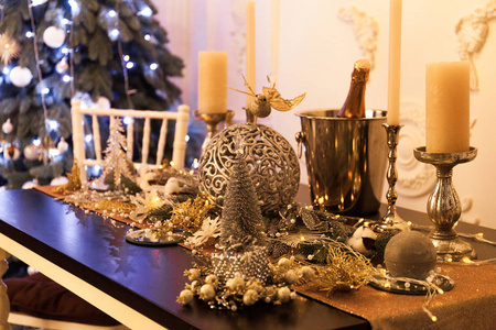 漂亮的餐桌上有装饰蜡烛。 客厅装饰着灯和圣诞树。 假期安排