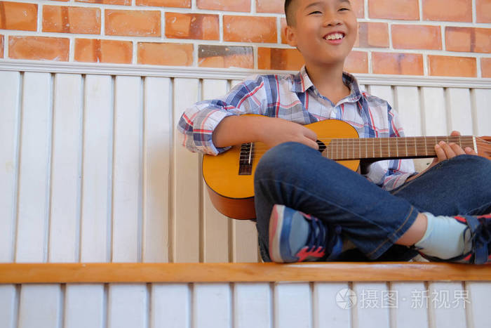 亚洲小孩在家弹吉他儿童休闲活动