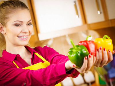 有趣快乐的女人拿着胡椒，美味健康的节食蔬菜，呈现饮食食物。