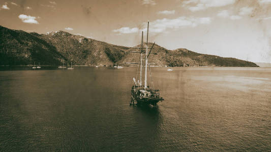 老帆船停泊在一个岛屿鸟瞰黑白。