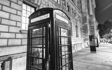 红色电话亭晚上在伦敦街英国。