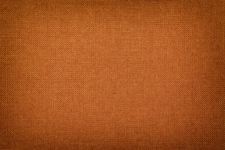 具有纹理的青铜织物的结构. 布橙色背景与紫罗兰.照片