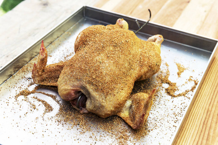 在烤盘上调味的生鸡，可供吸烟人士食用