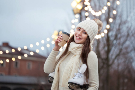 愉快的年轻妇女在针织毛衣和帽子是去滑冰和喝咖啡